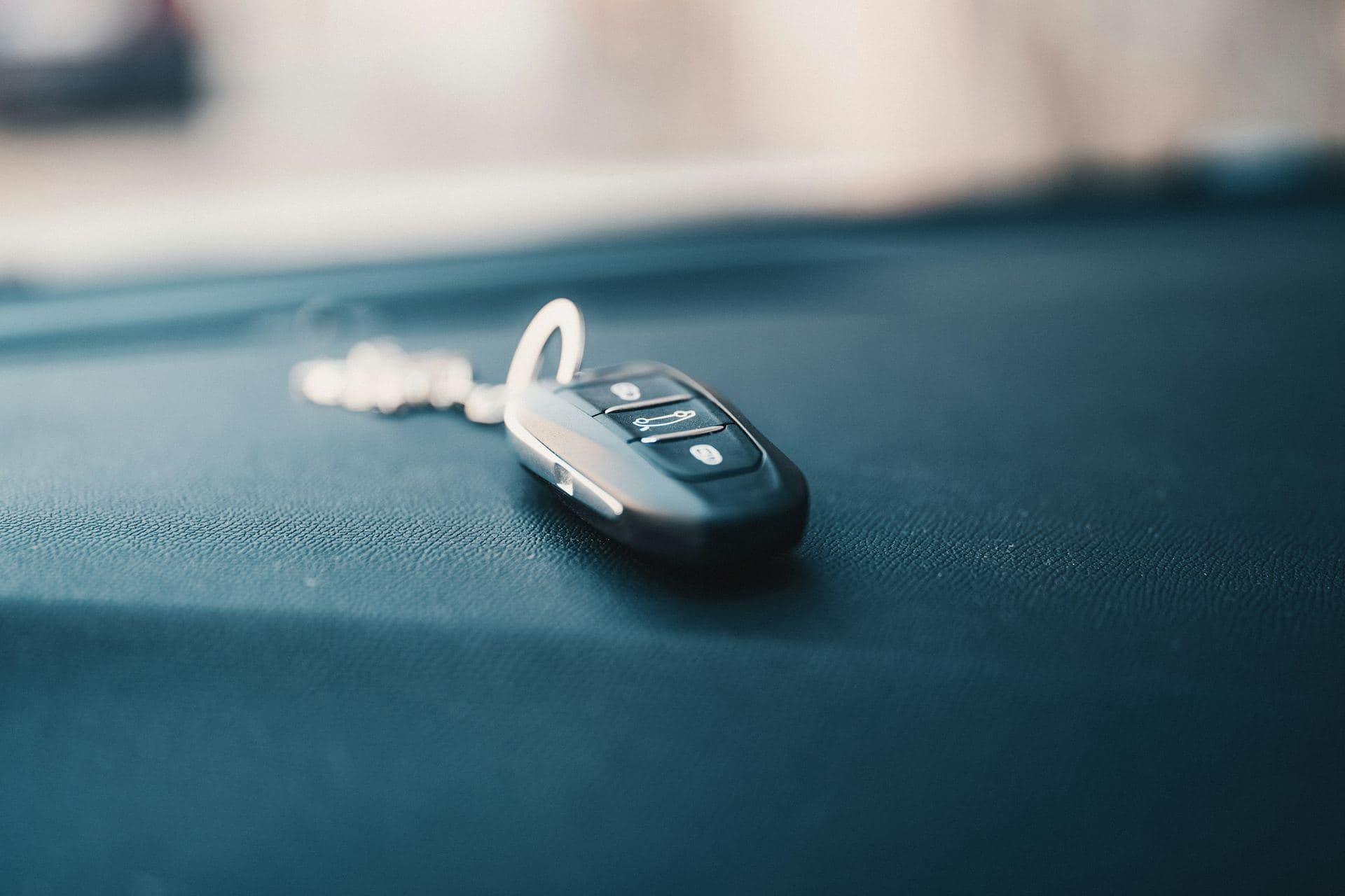 Clé de voiture à télécommande posée sur un tableau de bord gainé