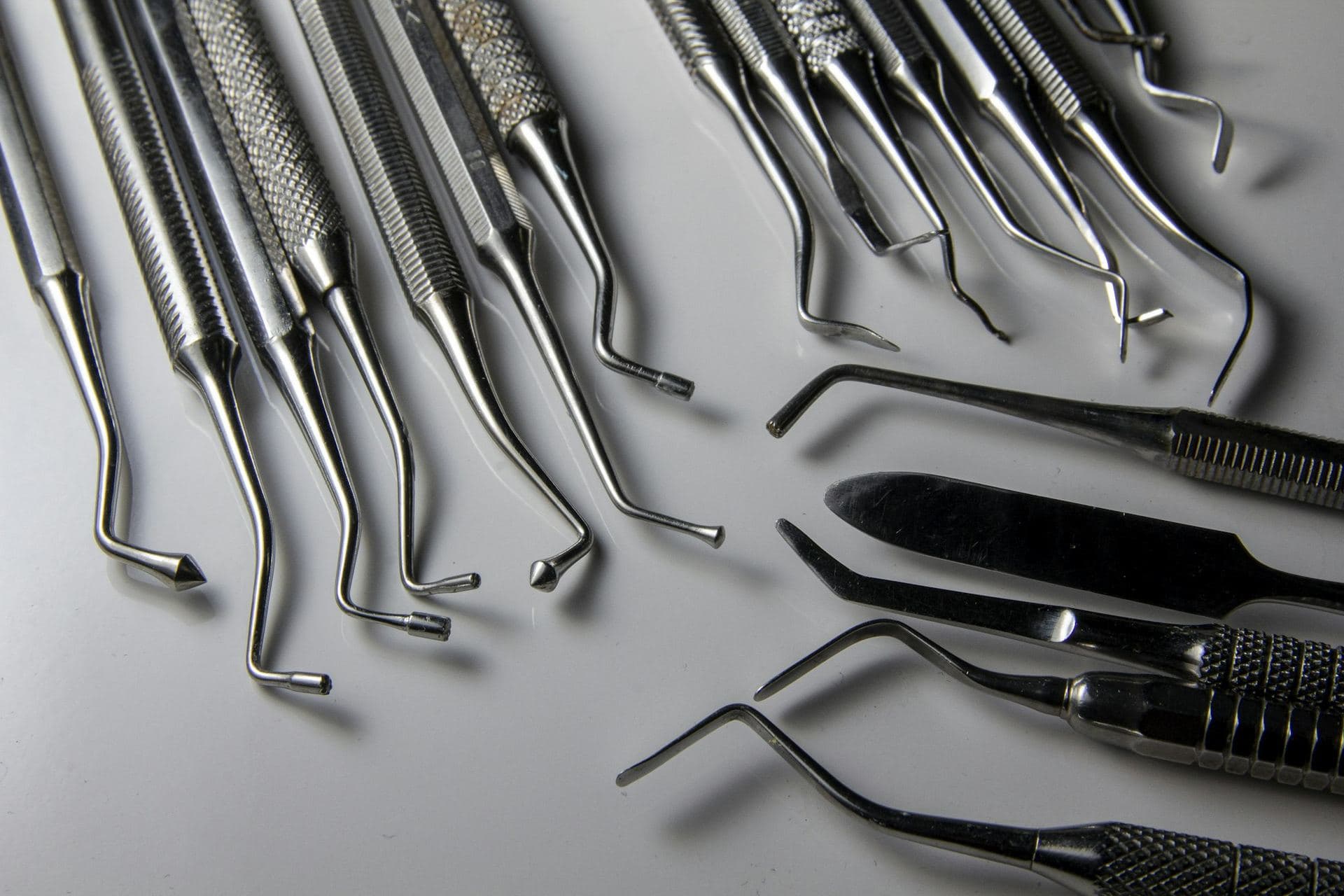 Instruments dentaires en acier alignés sur une surface claire